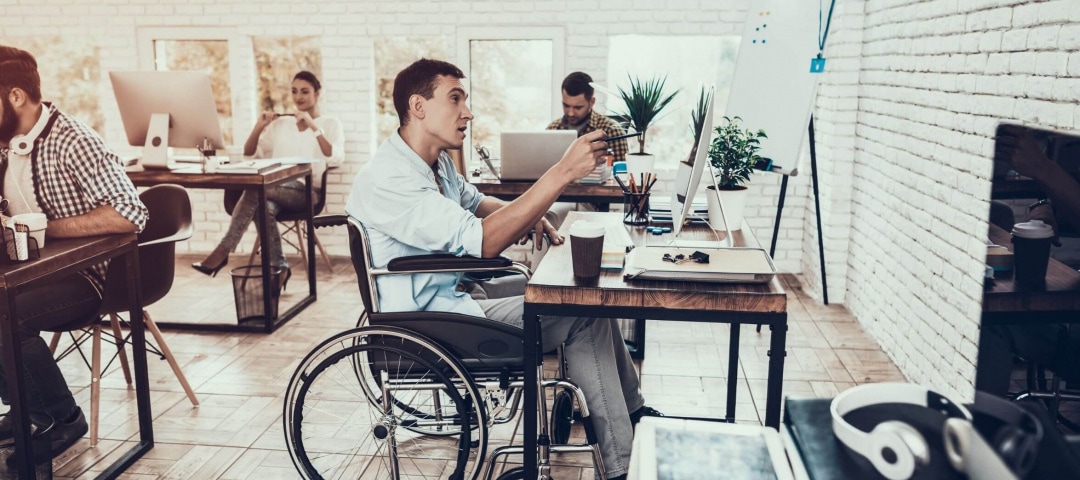 Mensch mit Rollstuhl am Arbeitsplatz